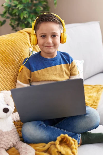 Adorable Hispanic Boy Using Laptop Headphones Sitting Sofa Home — Stok fotoğraf