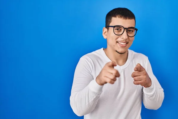 カジュアルな白いシャツとメガネを身に着けている若いアラブ人男性は 幸せで面白い顔をしてカメラに指を指しています 良いエネルギーと振動は — ストック写真