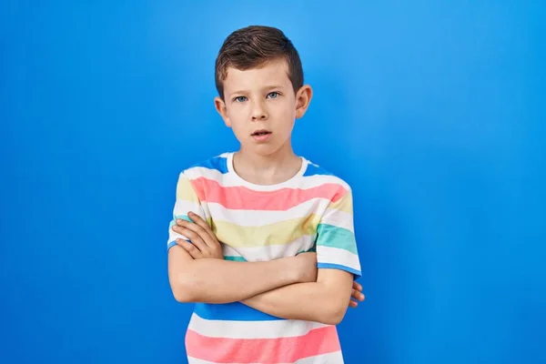 Młody Biały Dzieciak Stojący Nad Niebieskim Tłem Sceptyczny Nerwowy Dezaprobata — Zdjęcie stockowe
