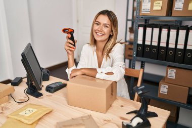 Genç İspanyol kadın ecommerce iş çalışanı ofiste tarama paketi