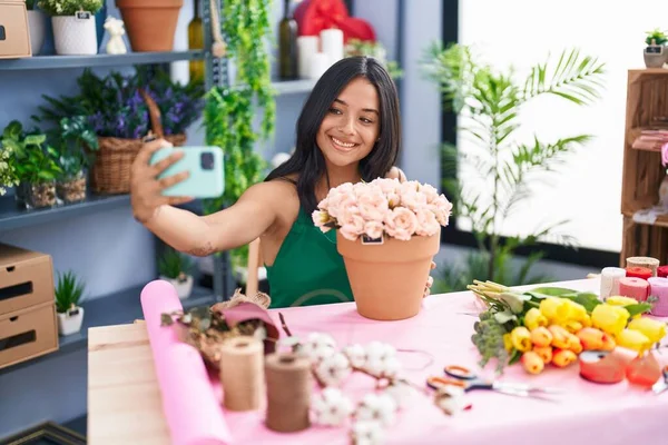Young Hispanic Woman Florist Make Selfie Smartphone Sitting Table Florist — Zdjęcie stockowe