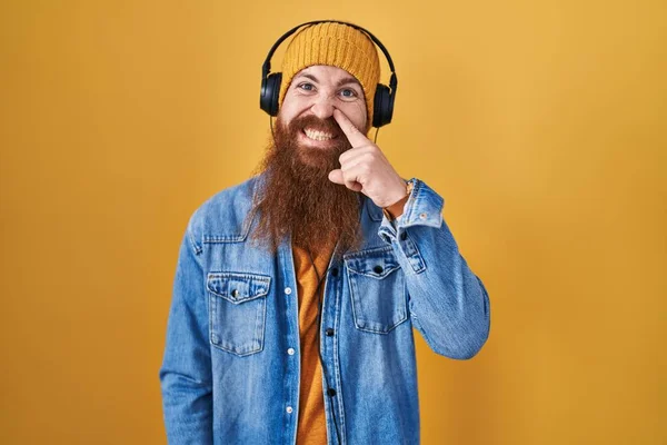 Caucasian Man Long Beard Listening Music Using Headphones Pointing Hand — Stockfoto