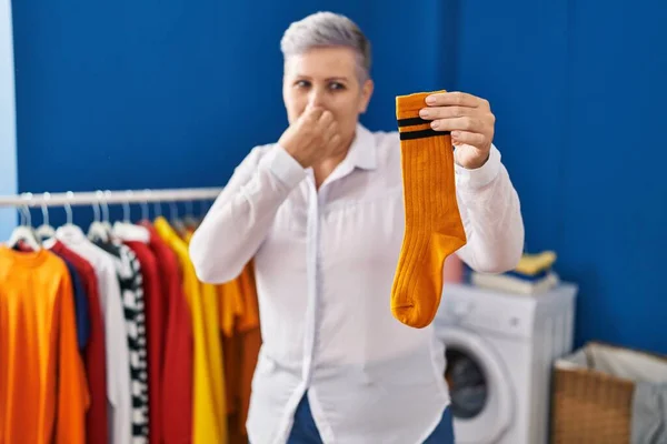 Middle Age Woman Smiling Confident Smelling Dirty Sock Laundry Room — Stock Photo, Image