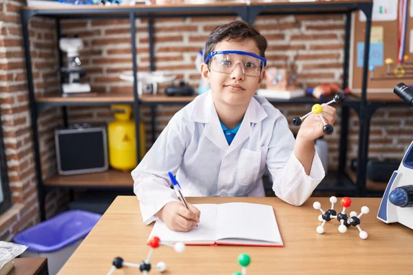 Entzückender Hispanischer Junge Schreibt Auf Notizbuch Mit Molekülen Labor Klassenzimmer — Stockfoto