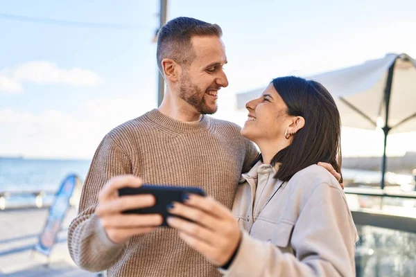 Άνδρας Και Γυναίκα Ζευγάρι Χαμογελά Αυτοπεποίθηση Χρησιμοποιώντας Smartphone Στην Παραλία — Φωτογραφία Αρχείου
