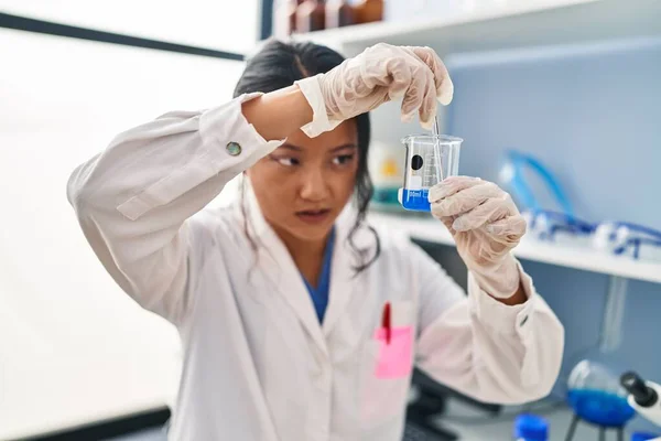 研究室で科学者の均一な混合液を身に着けている若い中国人女性 — ストック写真