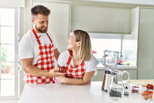 Genç Çift Mutfakta Kırmızı Elma Tutarken Kendinden Emin Gülümsüyor — Stok fotoğraf