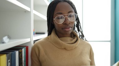 African woman reading a book at library university