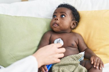 Afrika kökenli Amerikalı bebek yatak odasında muayene oluyor.