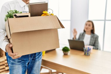 Orta yaşlı erkek ve kadın işçiler çalışanı kovuyor.