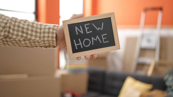 Middle age man smiling confident holding blackboard at new home