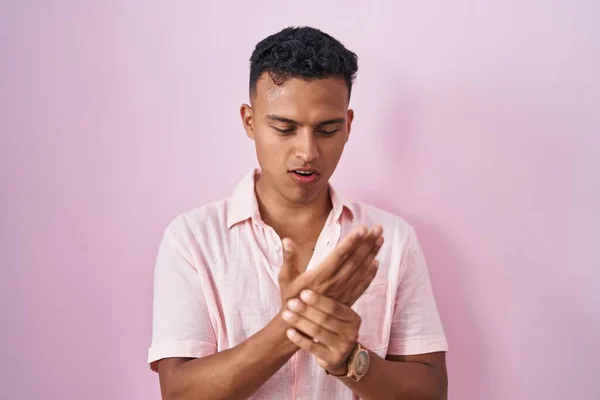 Homem Hispânico Jovem Sobre Fundo Rosa Sofrendo Dor Nas Mãos — Fotografia de Stock