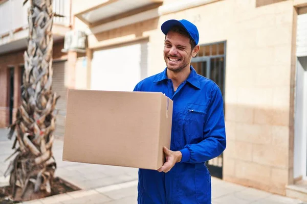 Young Hispanic Man Delivering Box Winking Looking Camera Sexy Expression — Stock Photo, Image