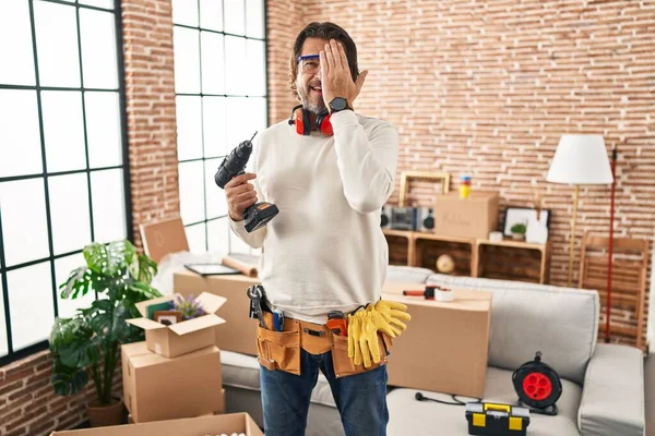 Handsome Middle Age Man Holding Screwdriver New Home Covering One — 스톡 사진