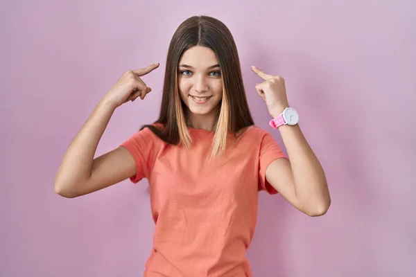 Chica Adolescente Pie Sobre Fondo Rosa Sonriendo Apuntando Cabeza Con —  Fotos de Stock