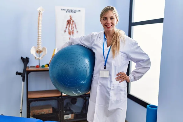 Beautiful Woman Holding Pilates Ball Physiotherapy Clinic Looking Positive Happy — Stockfoto