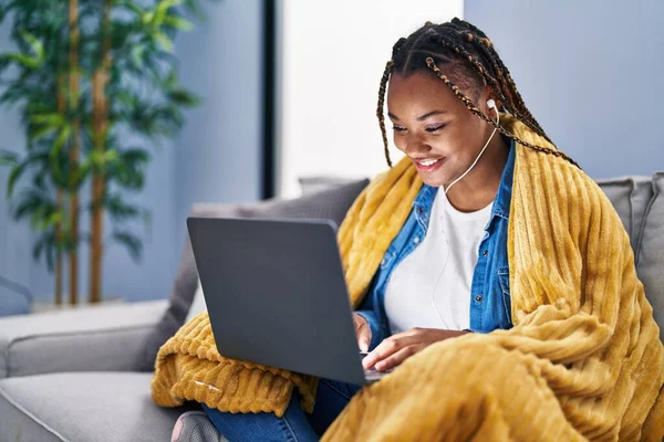 Afrikansk Amerikansk Kvinna Använder Laptop Och Hörlurar Sitter Soffan Hemma — Stockfoto