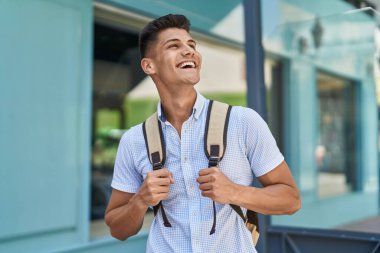 Sokakta kendinden emin gülümseyen genç İspanyol öğrenci.