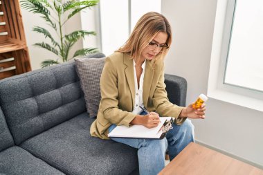 Young hispanic woman psychologist prescribe pills treatment at psychology center