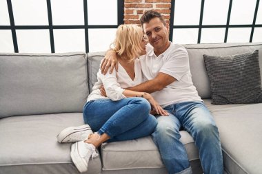 Middle age man and woman smiling confident hugging each other at home