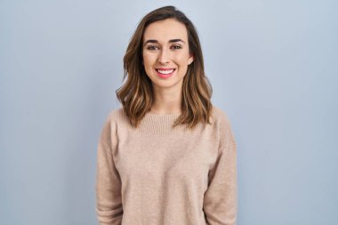 Soyutlanmış bir geçmişin başında mutlu ve havalı bir gülümsemeyle duran genç bir kadın. şanslı kişi. 