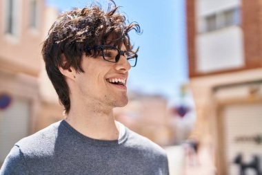 Sokakta kendine güvenen ve gülümseyen İspanyol genç adam.