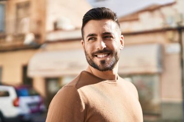 Sokakta kendinden emin gülümseyen İspanyol genç adam.