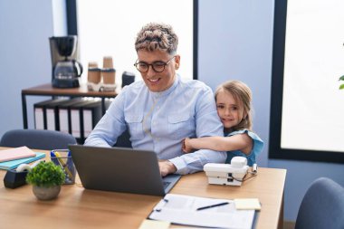 Baba ve kız iş adamı ve öğrenci ofiste çalışırken birbirlerine sarılıyorlar.