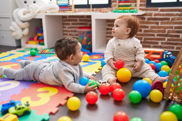 两个可爱的孩子在幼儿园的地板上玩球 — 图库照片