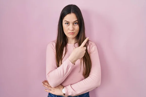 Young Brunette Woman Standing Pink Background Pointing Hand Finger Side — 图库照片