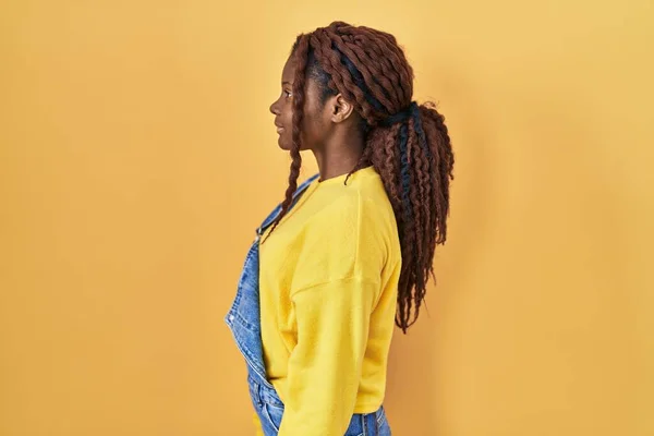 Sarı Arka Planda Dikilen Afrikalı Kadın Yan Bakmak Rahat Profil — Stok fotoğraf