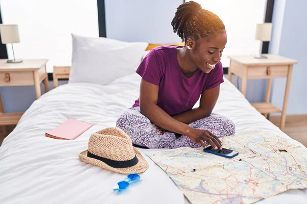 African American Woman Looking Map Using Smartphone Sitting Bed Bedroom — Fotografia de Stock