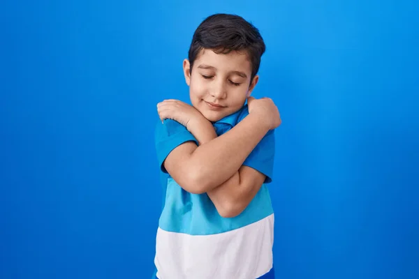 Kis Spanyol Fiú Áll Kék Háttér Fölött Öleli Magát Boldog — Stock Fotó