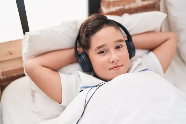 愛らしいHispanic男の子リッスンする音楽嘘でベッドルーム — ストック写真