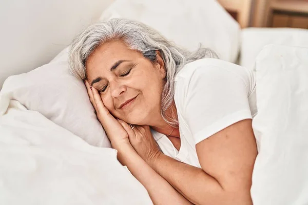 Middle age woman sleeping lying on bed at bedroom
