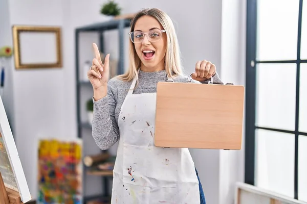 Young Blonde Painter Woman Holding Wooden Case Art Studio Smiling — Stock Photo, Image