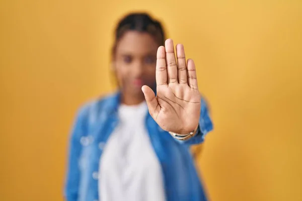 站在黄色背景上戴辫子的非洲裔美国妇女停下手心唱歌 用消极而严肃的手势警告人 — 图库照片