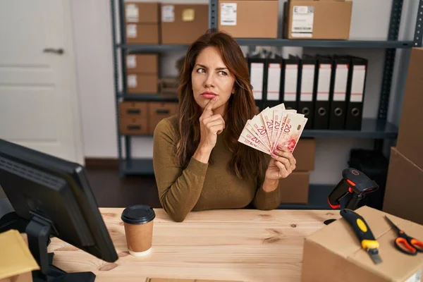 Hispanic Woman Working Small Business Ecommerce Holding Shekels Serious Face — Stok fotoğraf