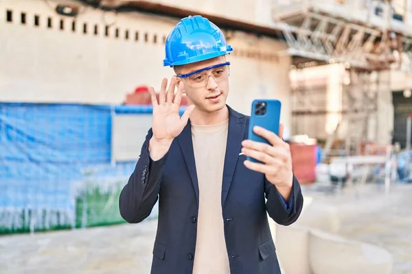 Young hispanic man architect having video call at street