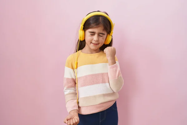 Little Hispanic Girl Listening Music Using Headphones Celebrating Surprised Amazed — Foto de Stock