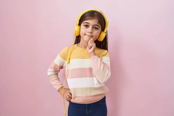 Little Hispanic Girl Listening Music Using Headphones Thinking Concentrated Doubt — Foto de Stock
