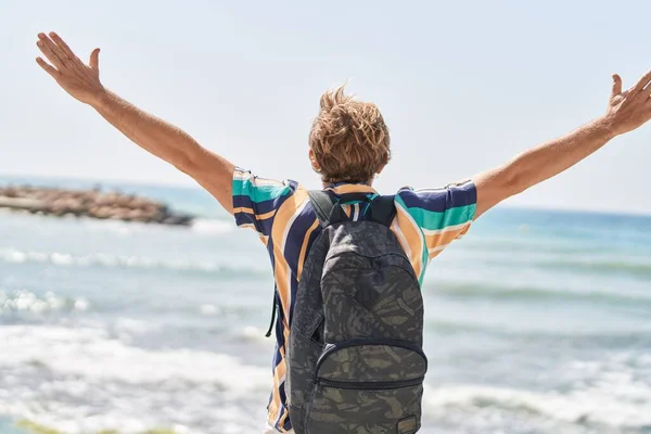 年轻男子游客背着背包 双臂张开 在海滨 — 图库照片