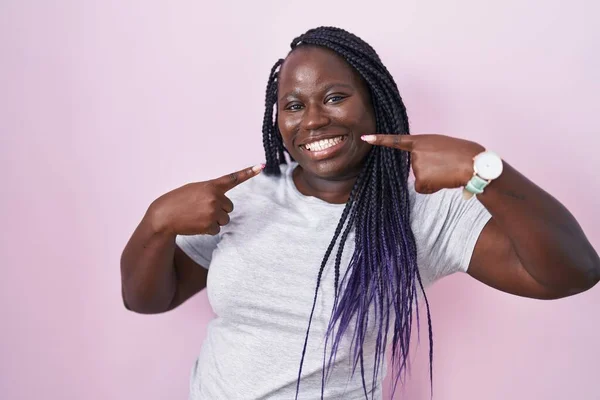 Jonge Afrikaanse Vrouw Staat Roze Achtergrond Lachend Vrolijk Tonen Wijzen — Stockfoto