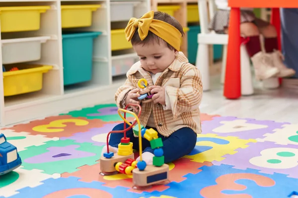 Sevimli Sarışın Çocuk Yerde Oturup Anaokulunda Oyuncaklarla Oynuyor — Stok fotoğraf