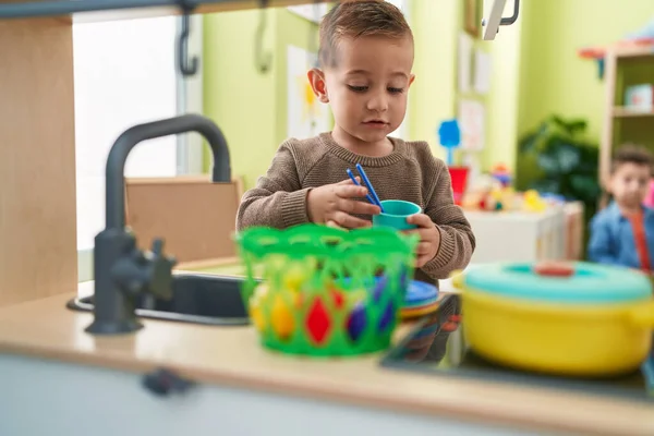 Adorable Hispanic Boy Playing Play Kitchen Standing Kindergarten — Stok fotoğraf
