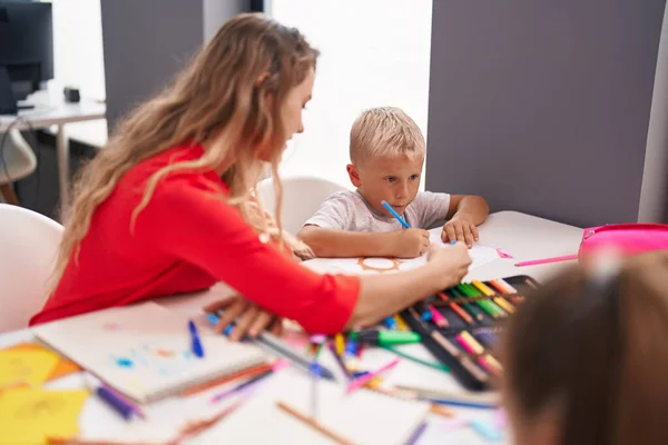 教室里 老师和幼儿坐在桌子上 画着纸 — 图库照片