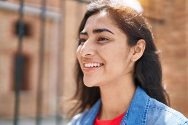 Young hispanic girl smiling confident looking to the side at street
