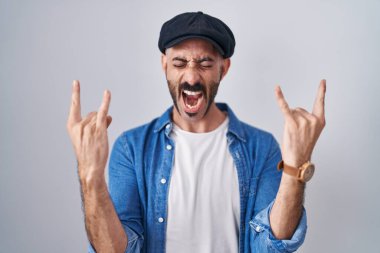 Arka planda sakallı, çılgın bir ifadeyle elleri havada rock sembolü yaparak bağıran İspanyol bir adam. Müzik yıldızı. ağır müzik konsepti. 