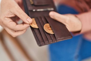 Orta yaşlı kadın elinde deri cüzdan tutuyordu.