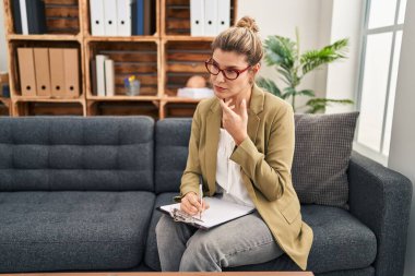 Genç sarışın kadın psikolog psikoloji merkezinde danışmanlık yapıyor.